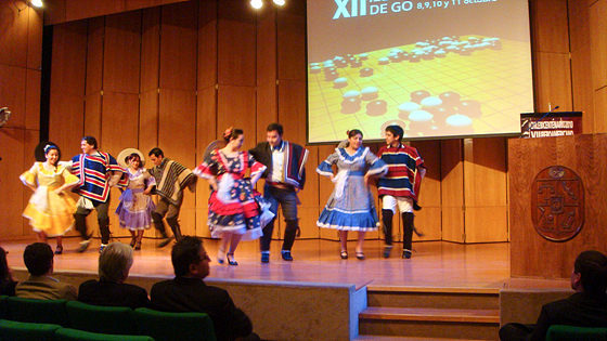 Чилийские национальные танцы, на фоне доски и и камней для Го